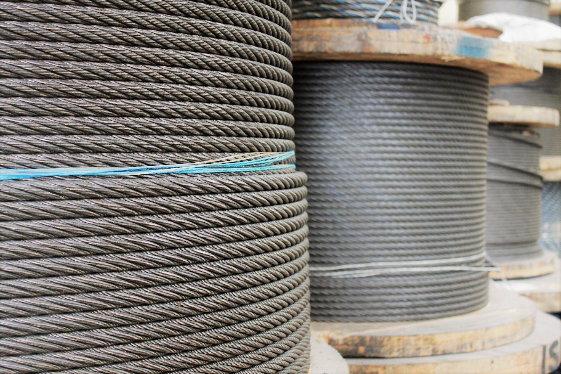 Carretes de cable de acero grueso y enrollado, firmemente enrollados, apilados en carretes de madera.