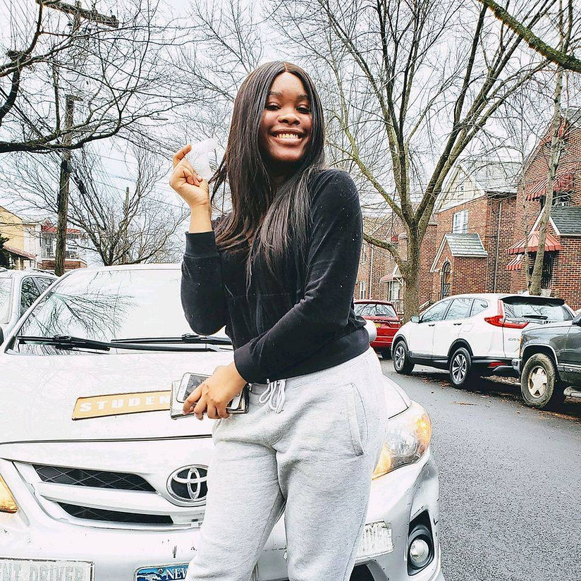 A woman is standing in front of a toyota car