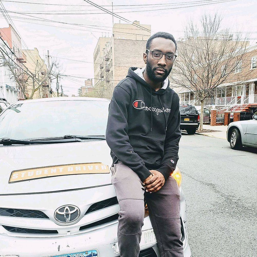 A man is sitting on the hood of a car.