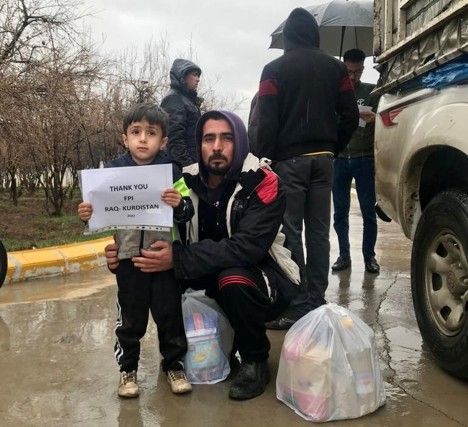 Man and young son holding a sign thanking Frontier Partners International