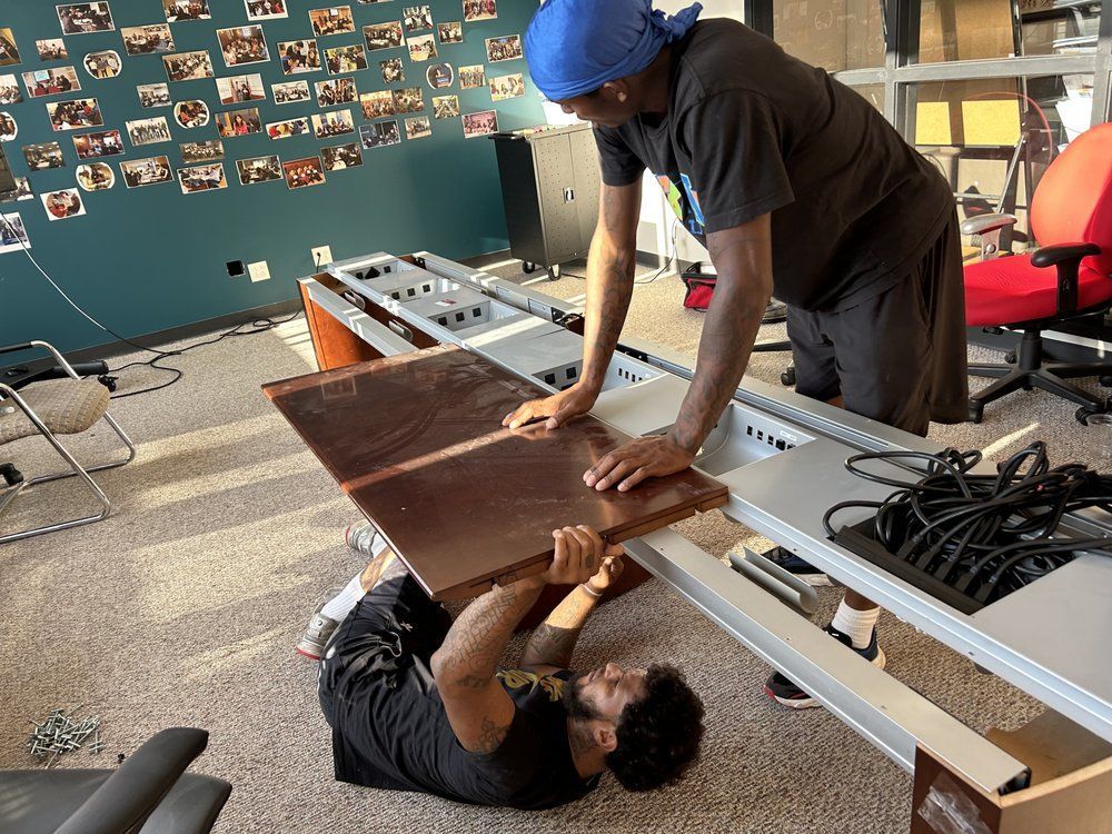 Diligent Alien Movers team members in Philadelphia disassembling office furniture with care and precision, ensuring a smooth and organized corporate relocation process.