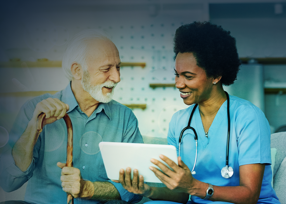 Nurse and patient looking at tablet; patient holding cane. Both are smiling.