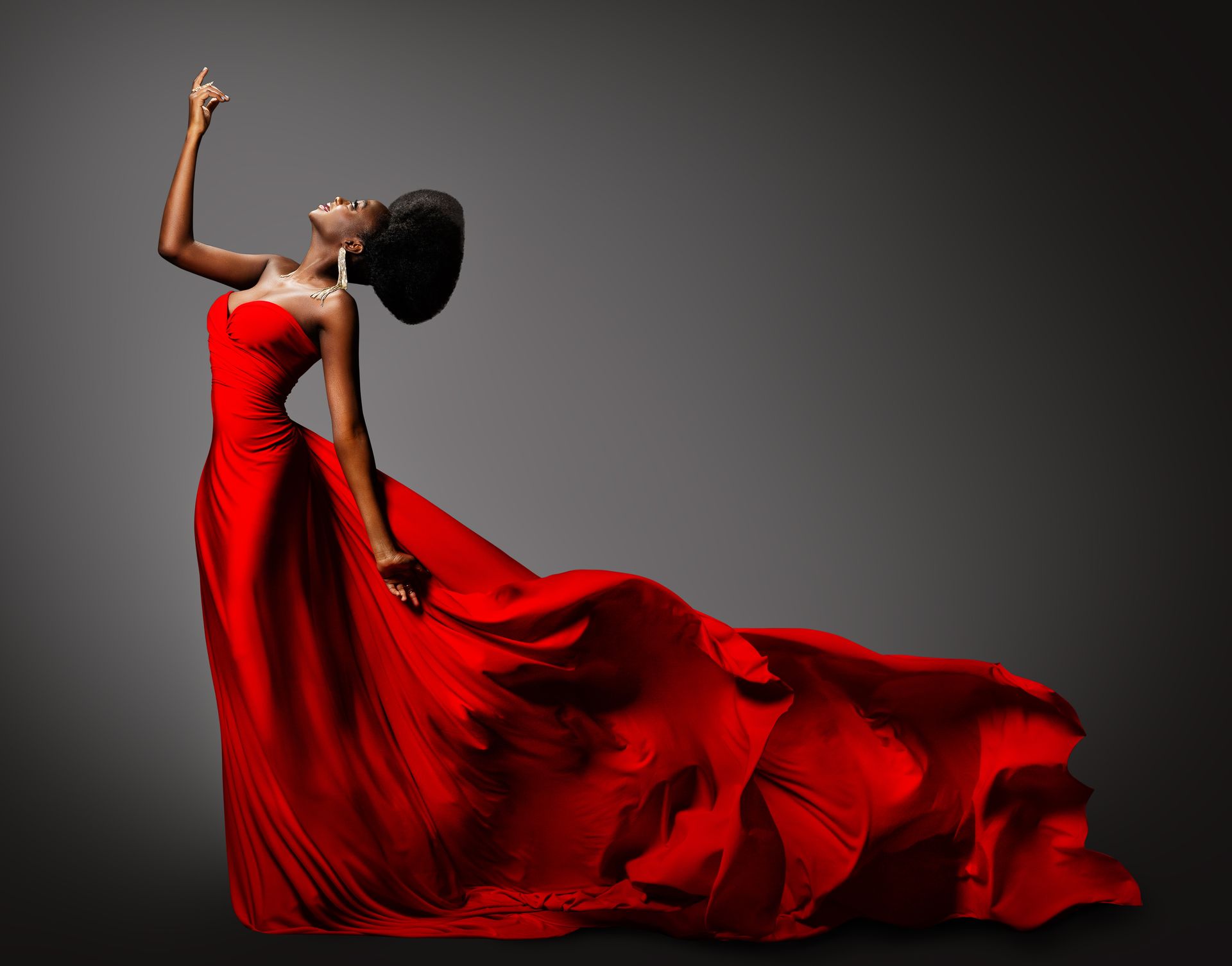 A woman in a long red dress is dancing.