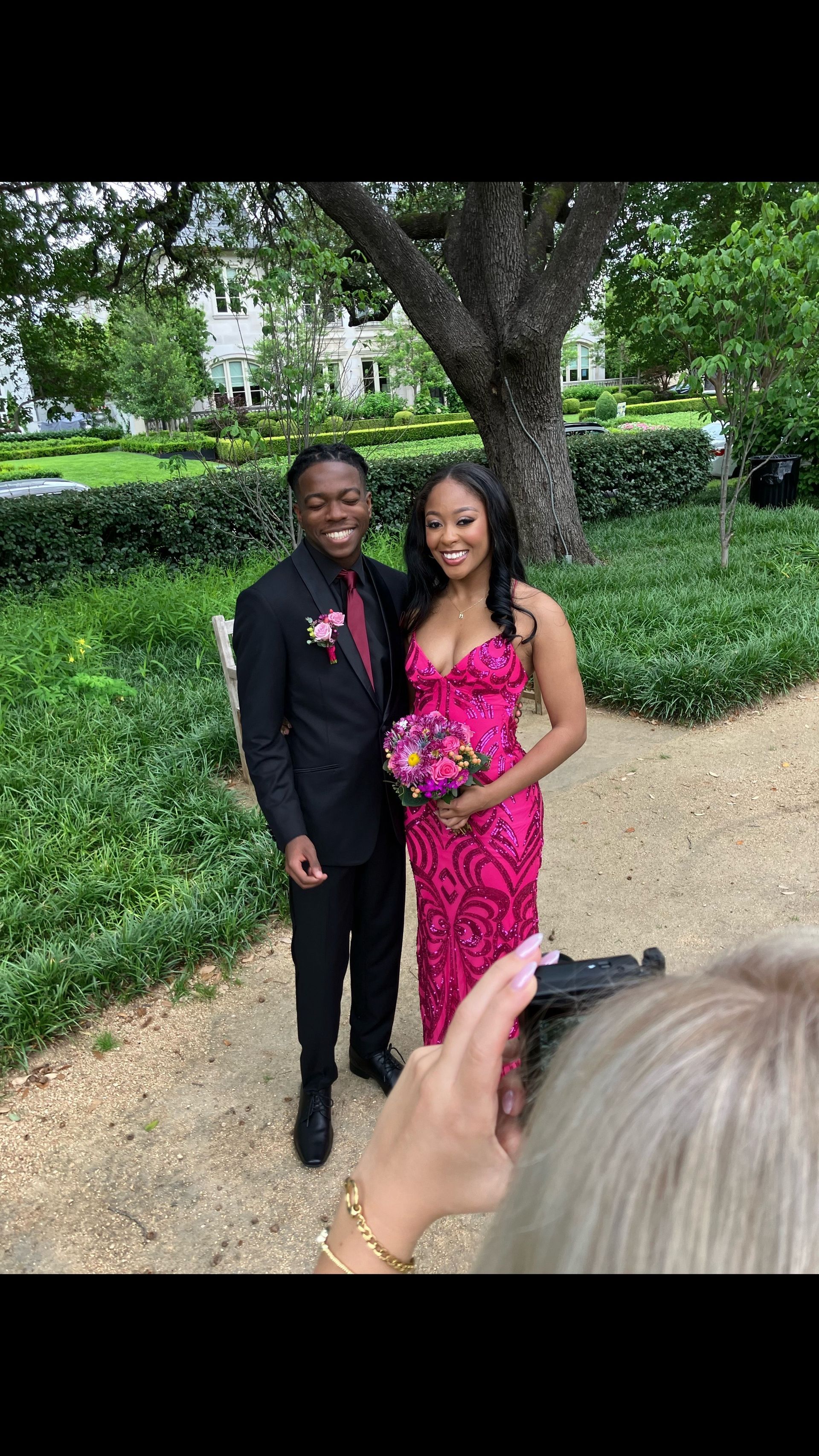 A man and a woman are posing for a picture in front of a tree.