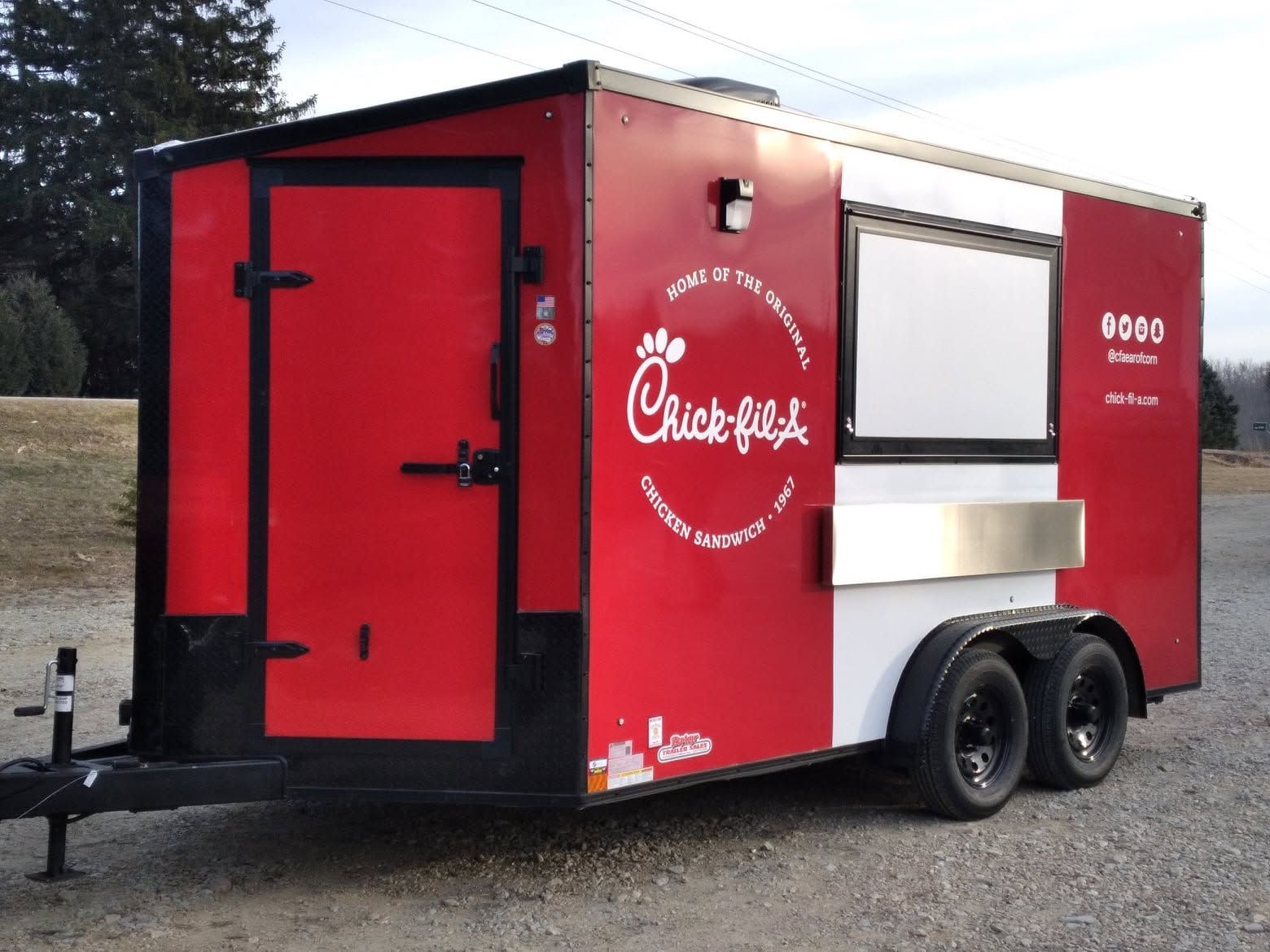Red Chick-fil-A food trailer with serving window, black trim, and two axles outdoors