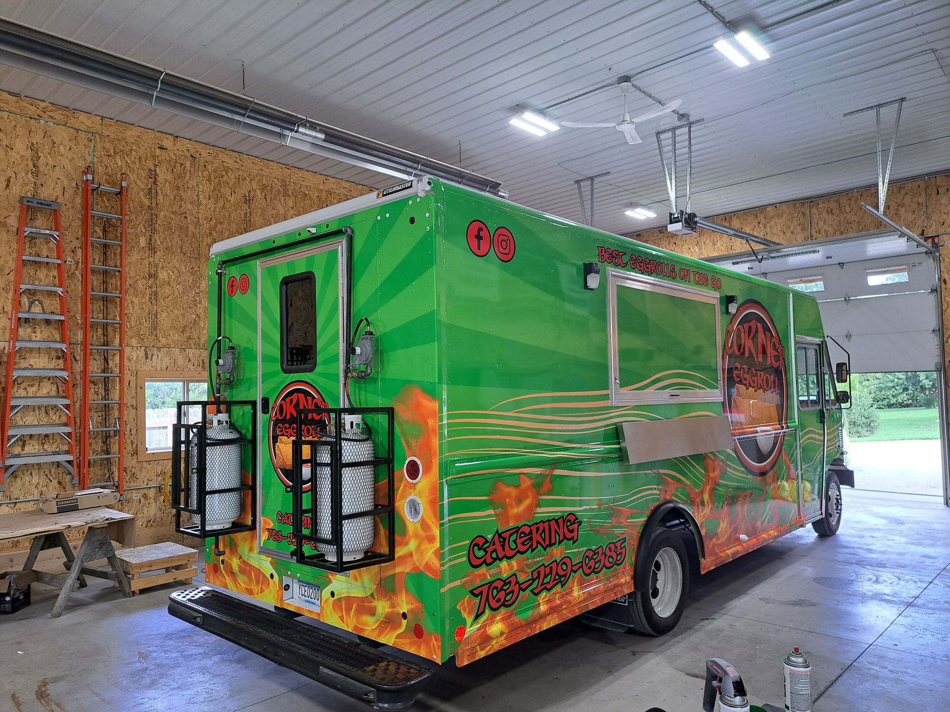 Bright green branded food truck parked indoors in a garage-like warehouse