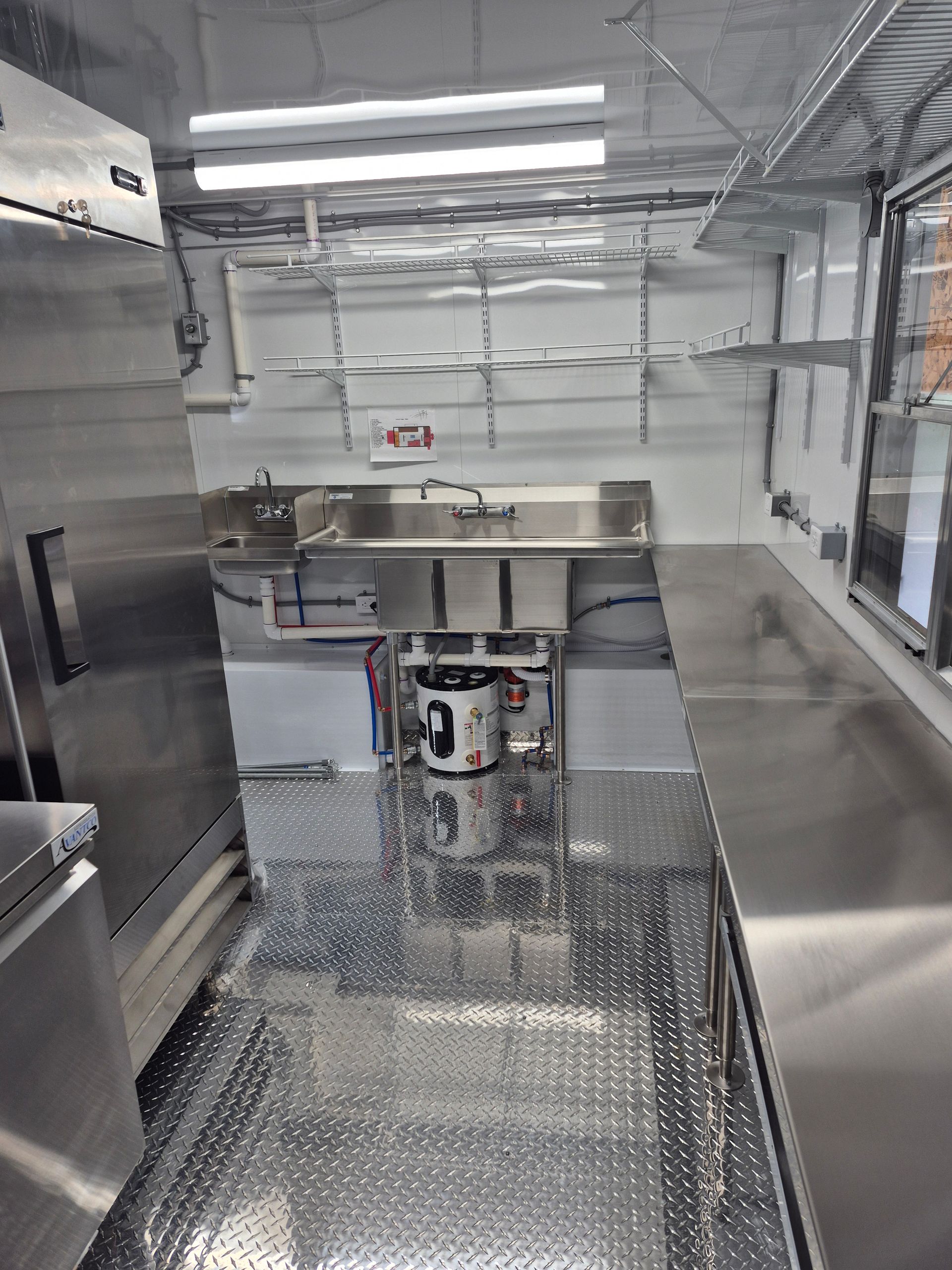 Industrial interior with metal floor, stainless steel counters, and bright overhead lights