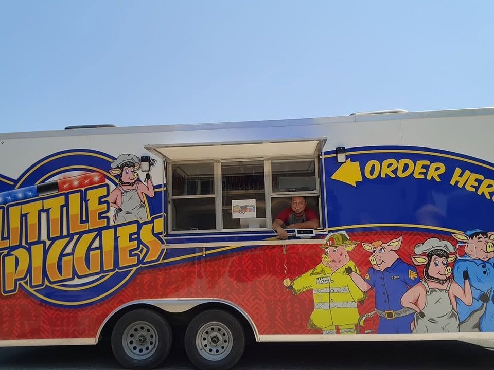 Little Piggies food truck with colorful cartoon graphics and an “ORDER HERE” window