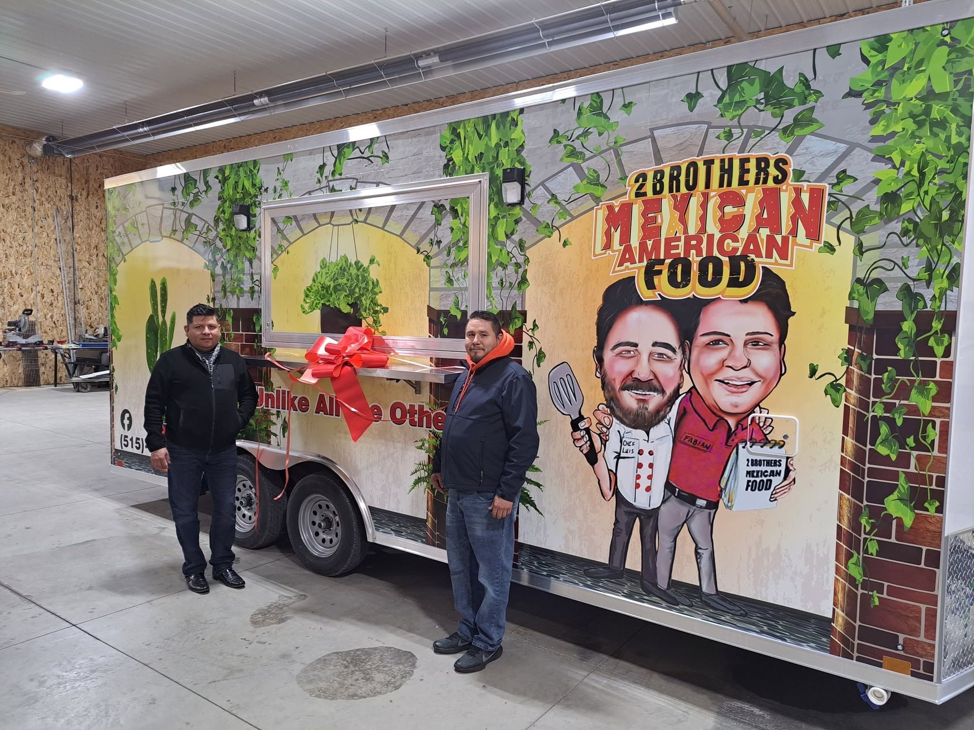 Food truck with colorful “Brothers Halal Food” mural, parked indoors, with two men standing beside it.