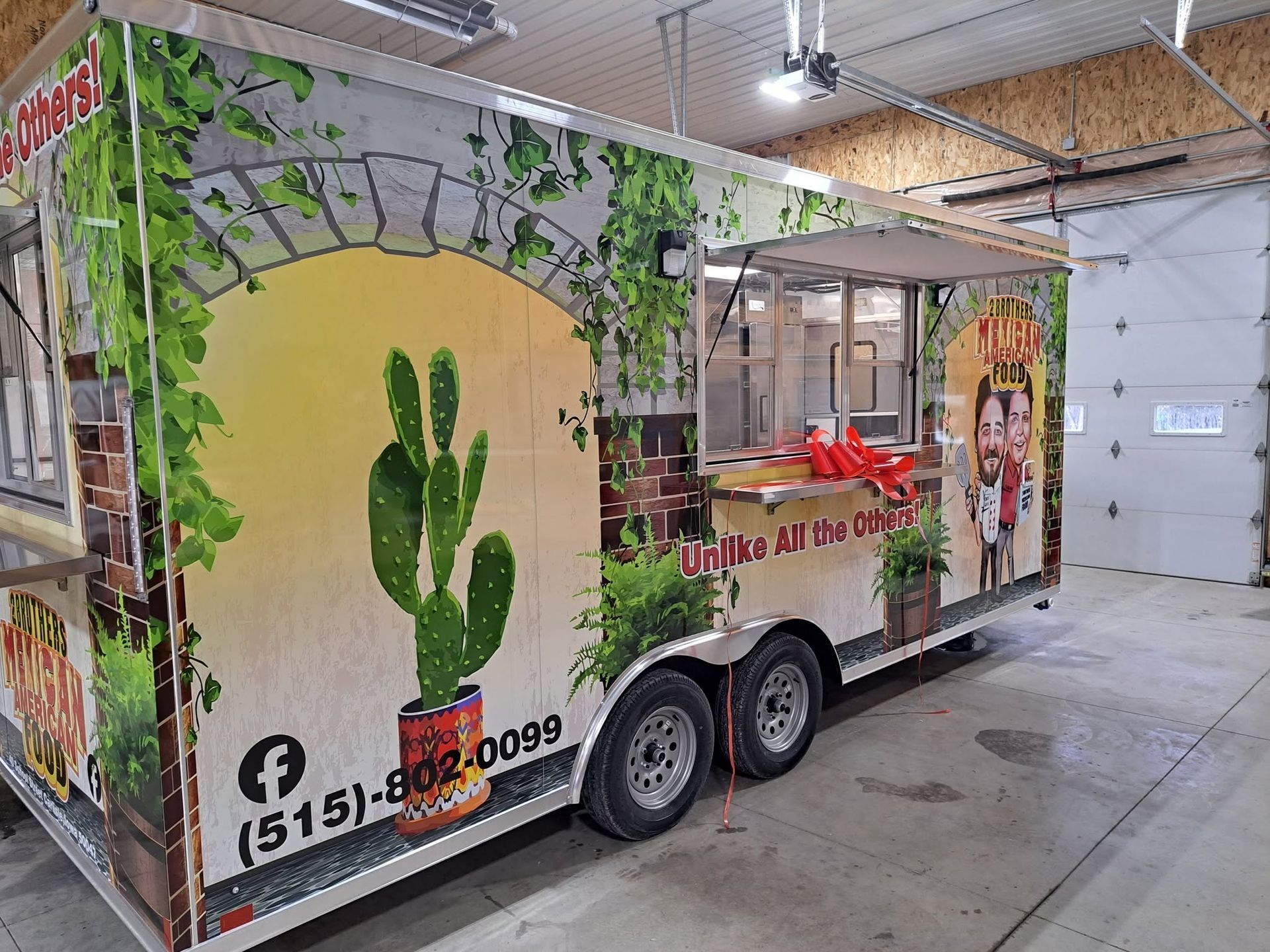 Cactus-themed food trailer in an indoor market, with green desert artwork and a serving window.
