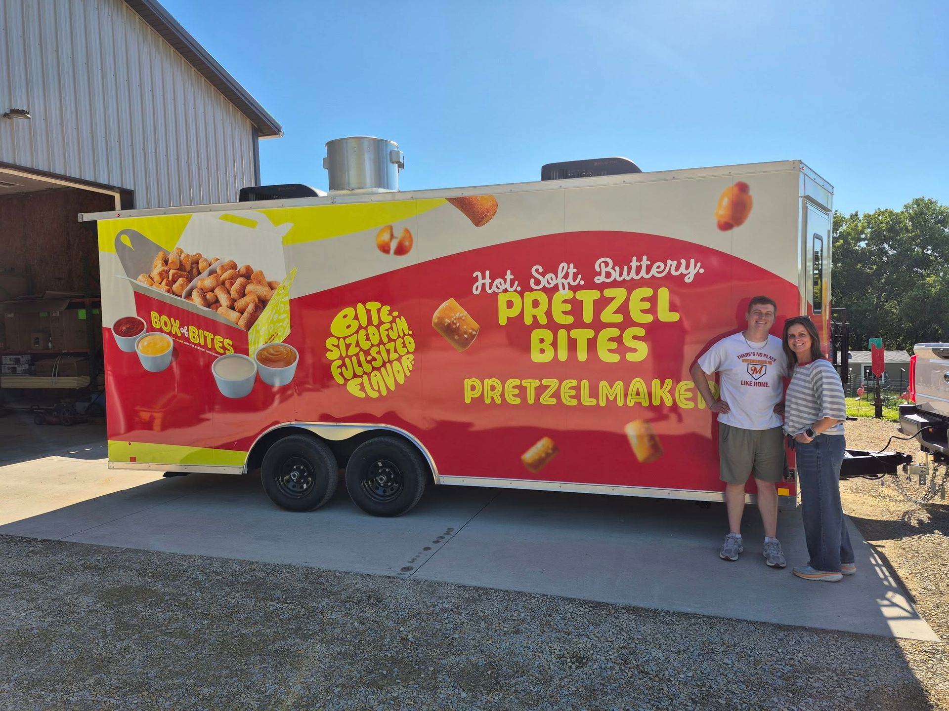 Red Pretzel Bites food truck with two people standing beside it outdoors