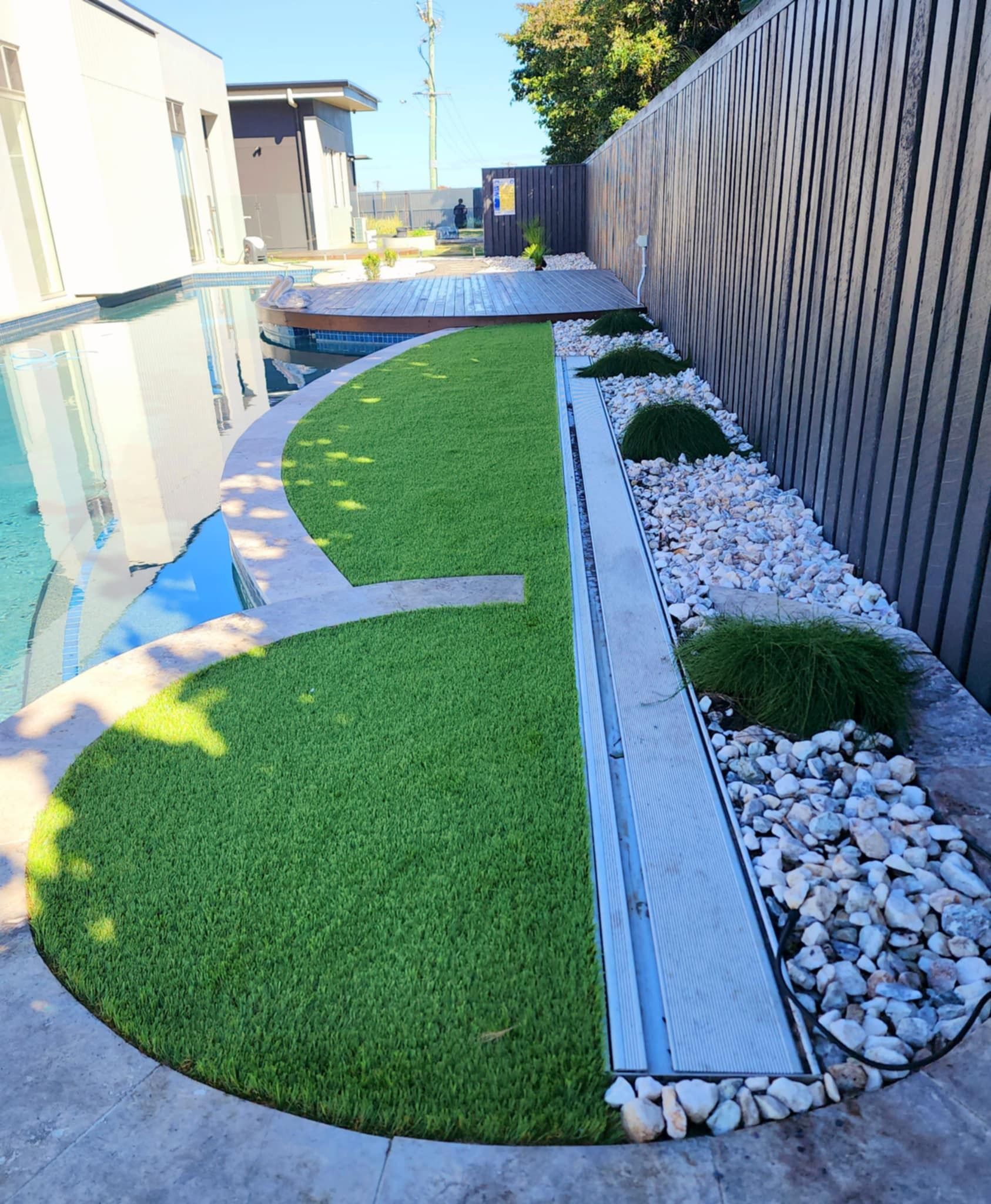 Backyard With Pool, Lawn, and Gravel Pathway Next to a Wooden Fence — On The Mark Landscaping in Branyan, QLD