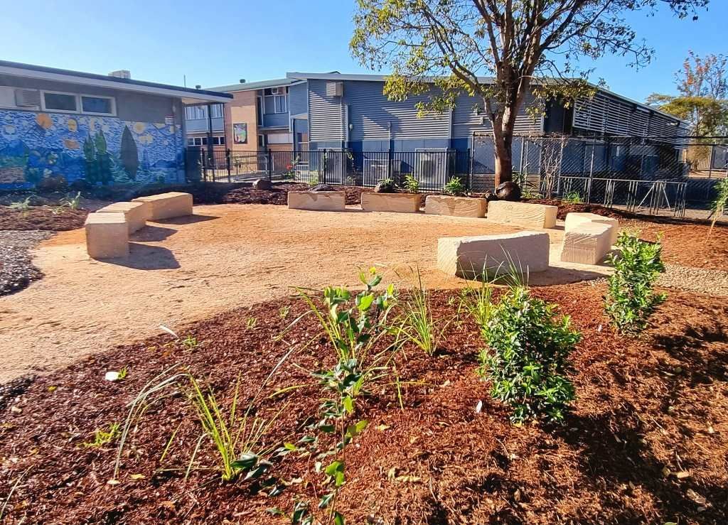 Outdoor Gathering Space With Stone Benches, Mulch, and Plants — On The Mark Landscaping in Branyan, QLD