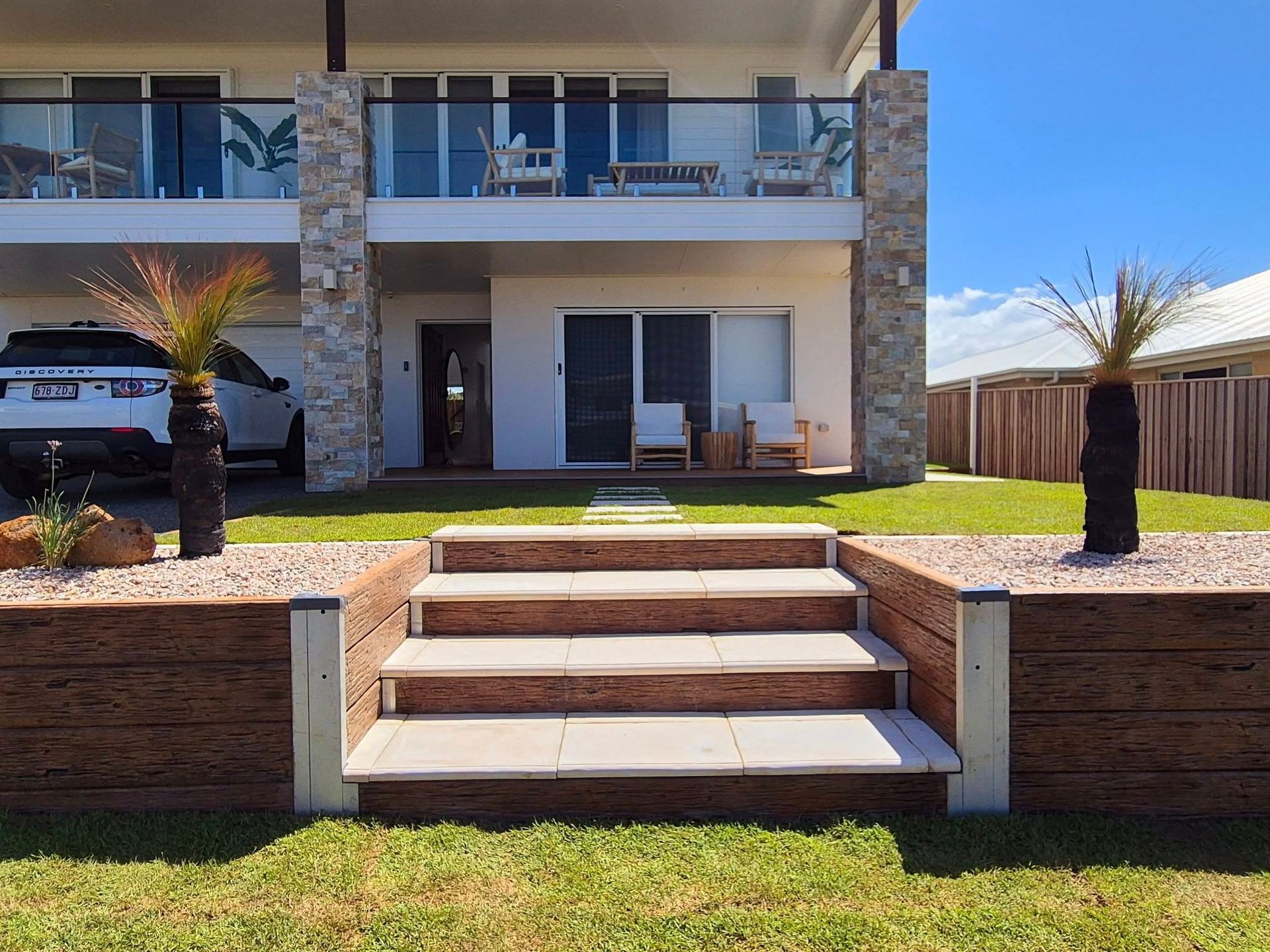 Front View of a Modern House With Stone Accents, Steps Leading to the Entrance — On The Mark Landscaping in Branyan, QLD