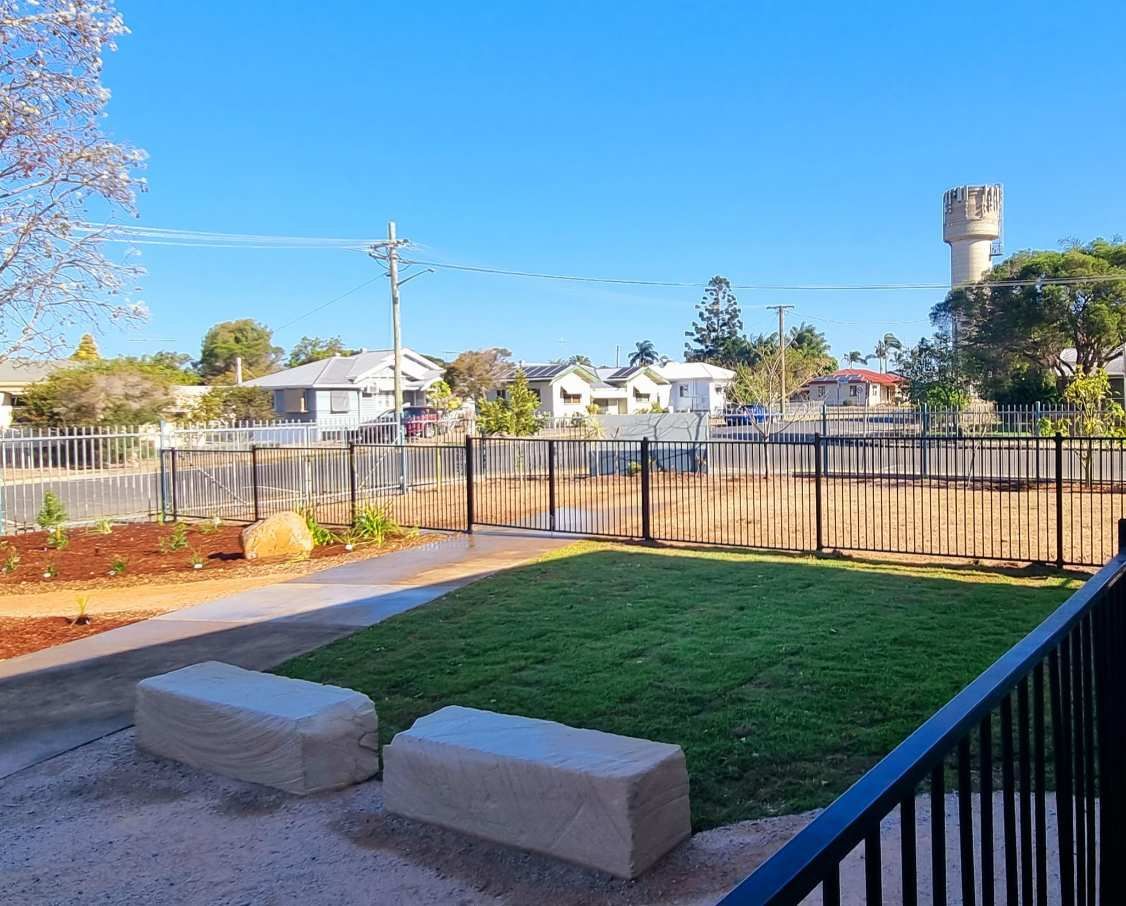 View of a Small Park With Grass, Stone Benches, a Fence, Houses — On The Mark Landscaping in Branyan, QLD
