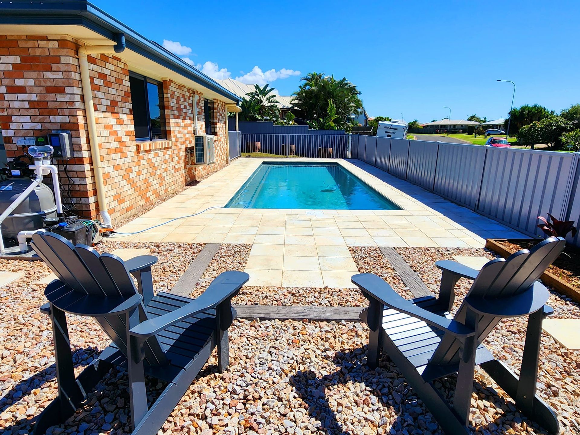 Two Adirondack Chairs Face a Rectangular Pool in a Backyard — On The Mark Landscaping in Branyan, QLD