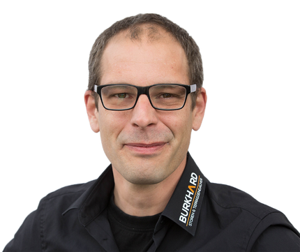 Ein Mann mit Brille und einem T-Shirt mit der Aufschrift „Burkhard“