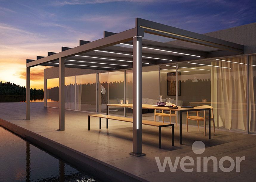 Eine Pergola mit einem Tisch und Bänken darunter.