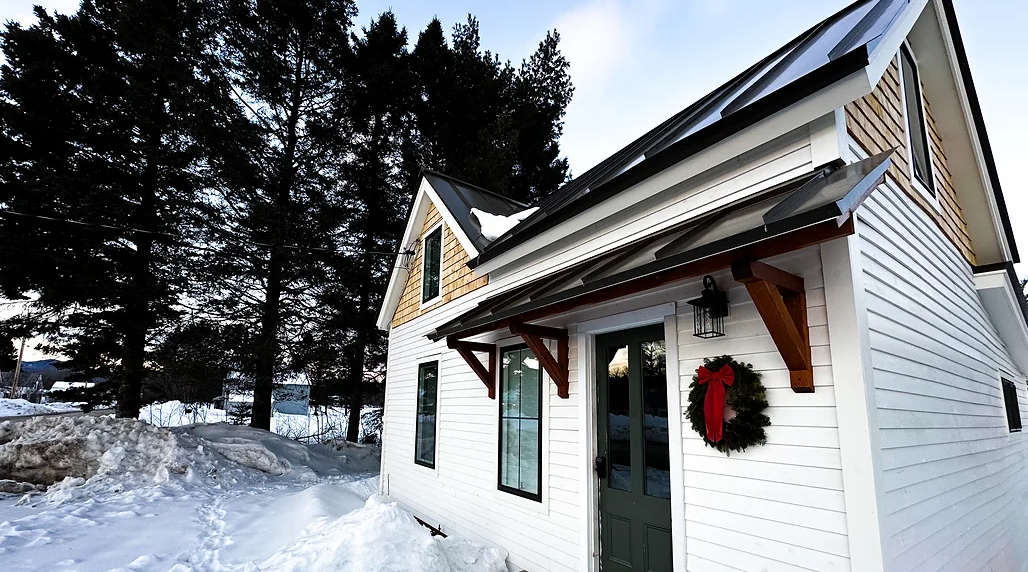 A small white house with a wreath on the front door