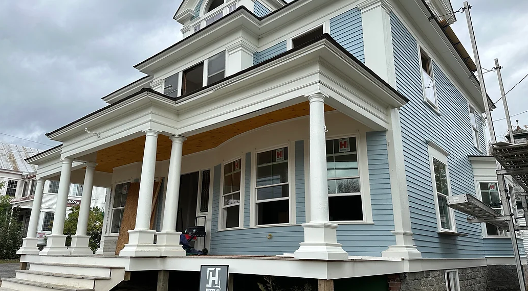 A large house with a porch and columns is being remodeled.