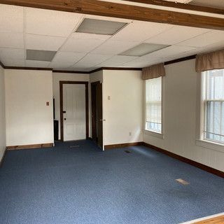 A large empty room with blue carpet and white walls.