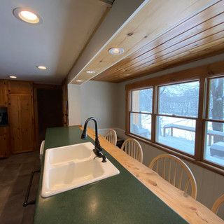 A kitchen with a sink and a wooden table and chairs.