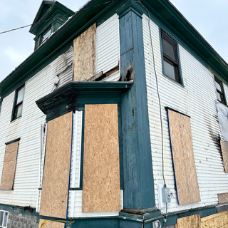 A house with a lot of windows boarded up