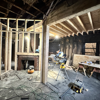 A room under construction with a brick fireplace