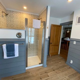A bathroom with a walk in shower and a towel rack.