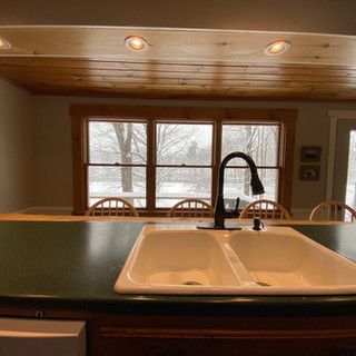 A kitchen sink is sitting on a counter in front of a window.