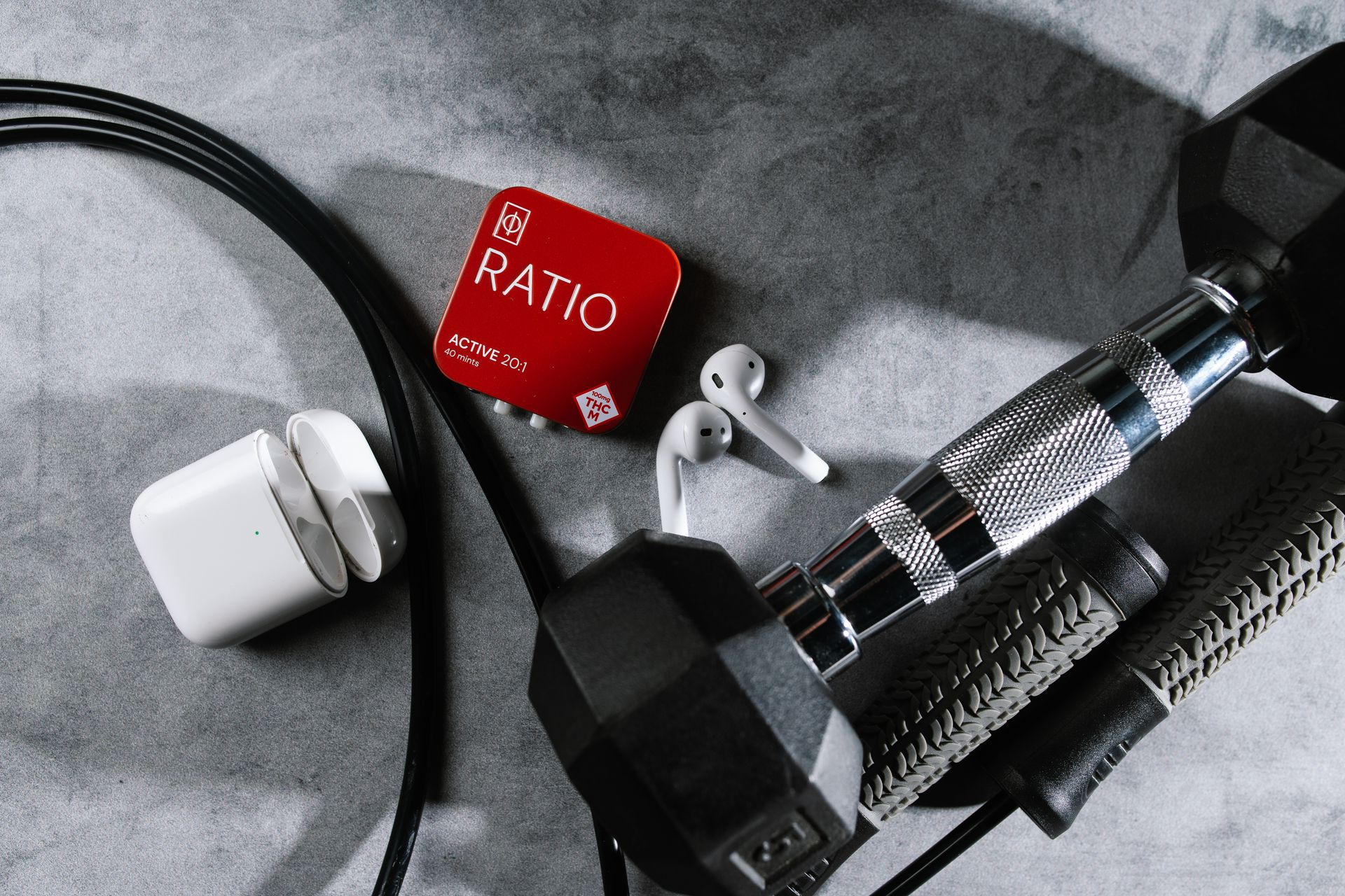 Black wire and red RATIO adapter attached to a chrome cable on a gray surface