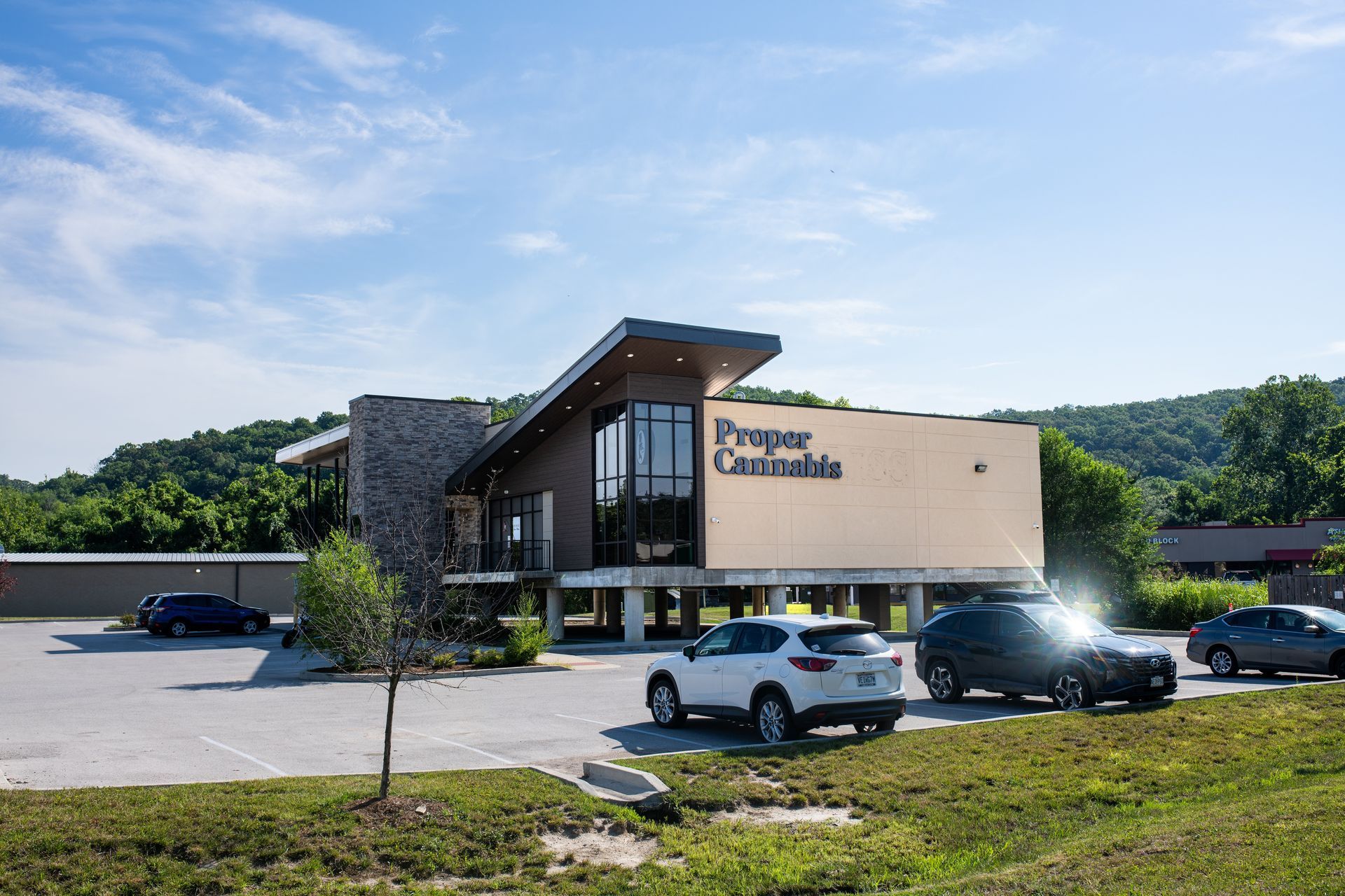 Modern building exterior with parked cars and a sign reading “Prosper Cantabria” under a blue sky