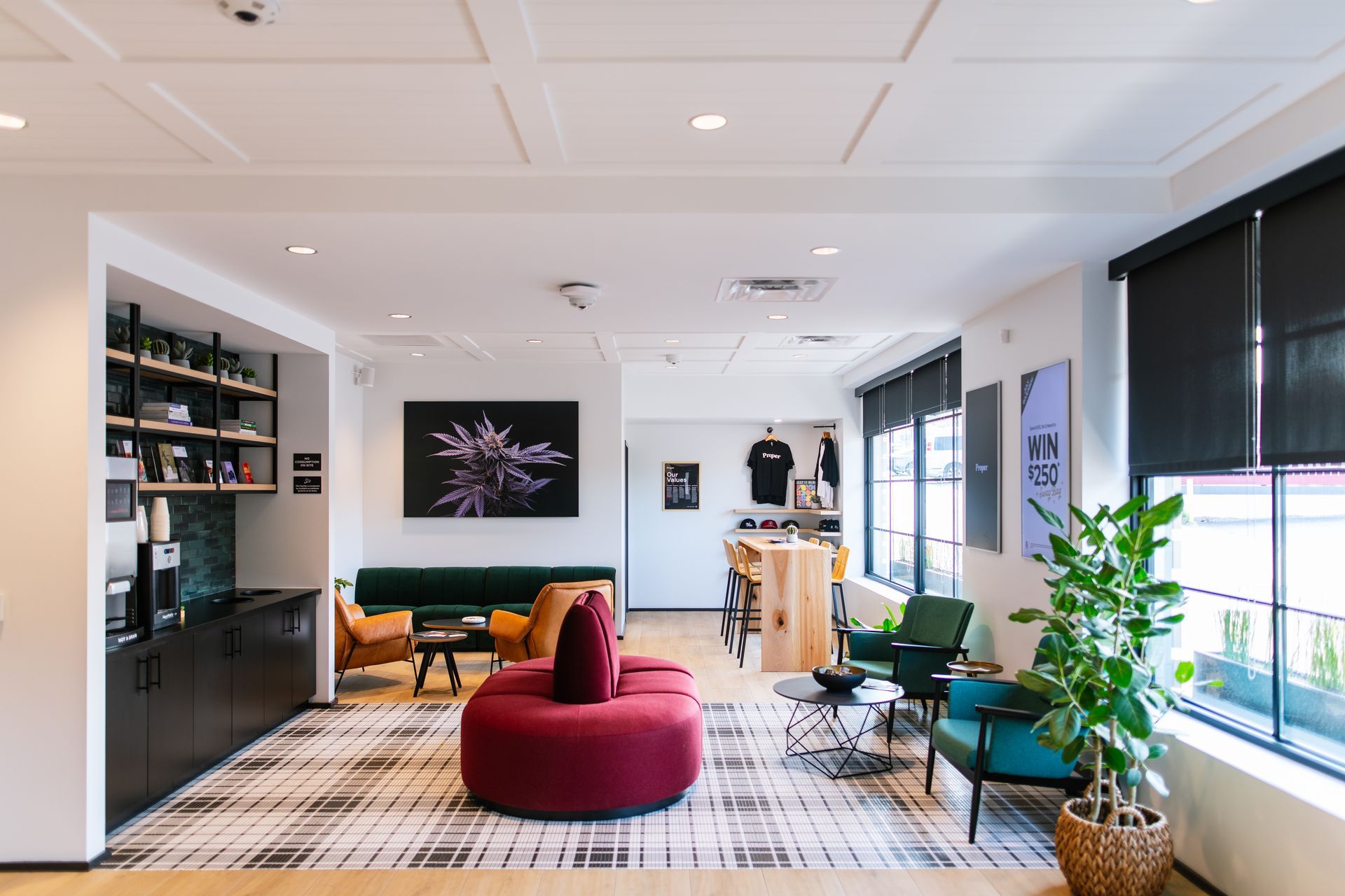 Modern open office lounge with red chairs, desks, plants, and large windows