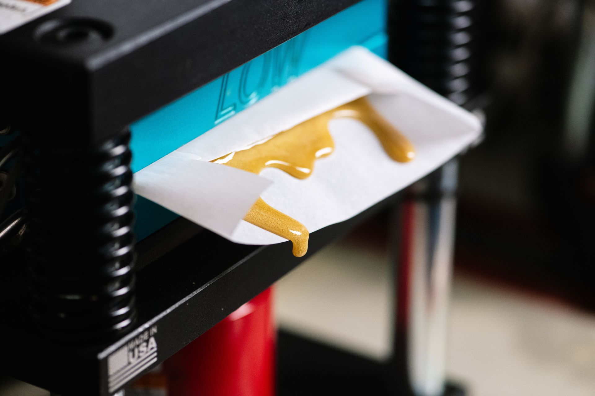 3D printer extruding yellow filament onto a white print bed