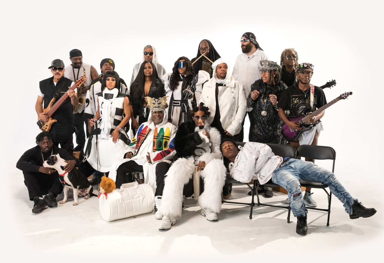 Large group posing in coordinated black-and-white outfits on a white studio backdrop