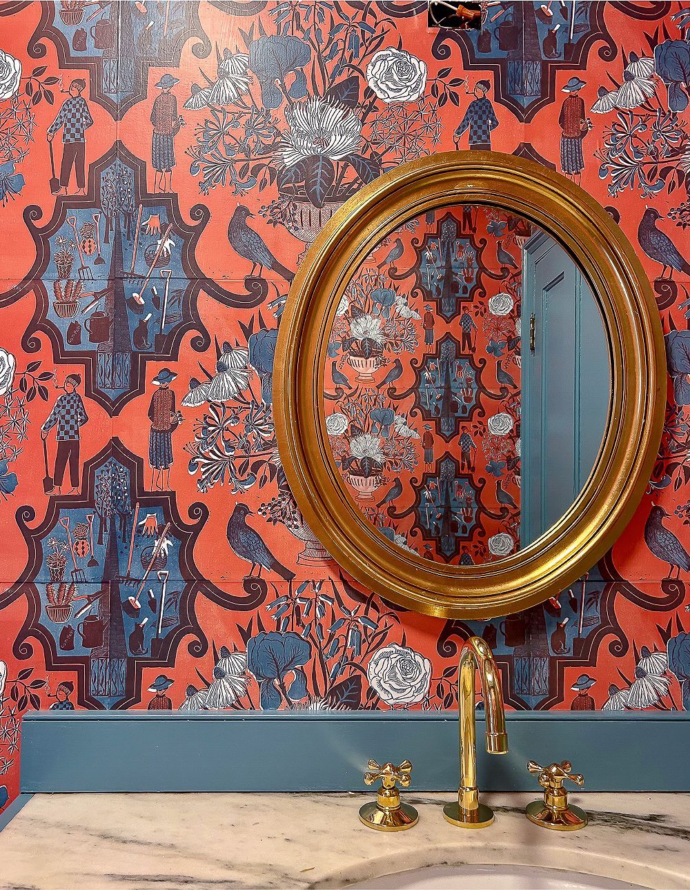 A bathroom with a sink , mirror , and wallpaper.