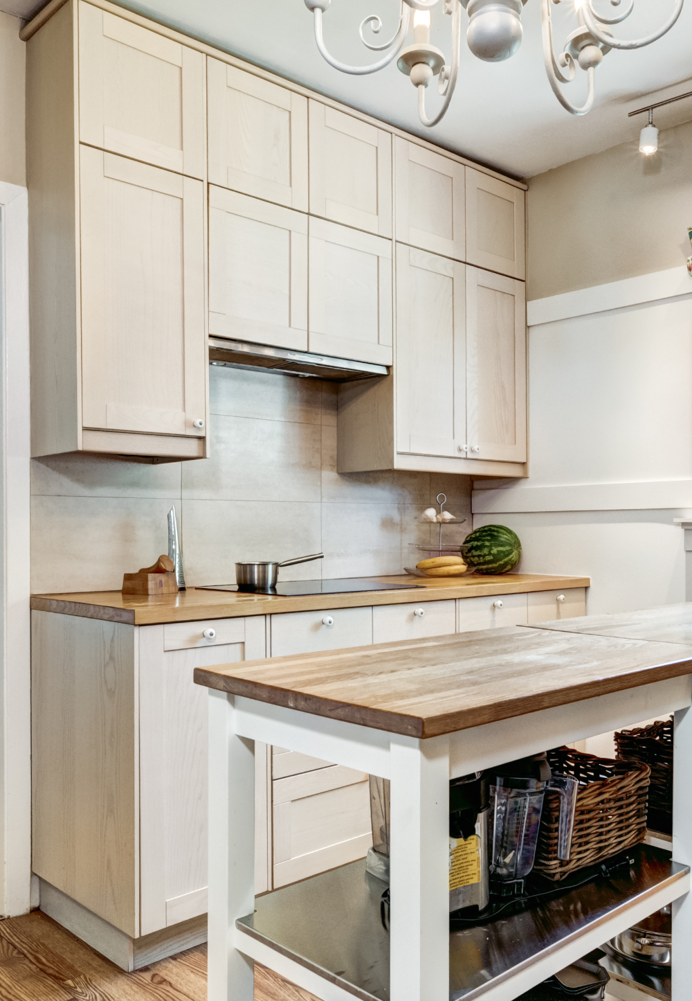 Light wood kitchen with cabinets, countertop, island, and overhead lighting.