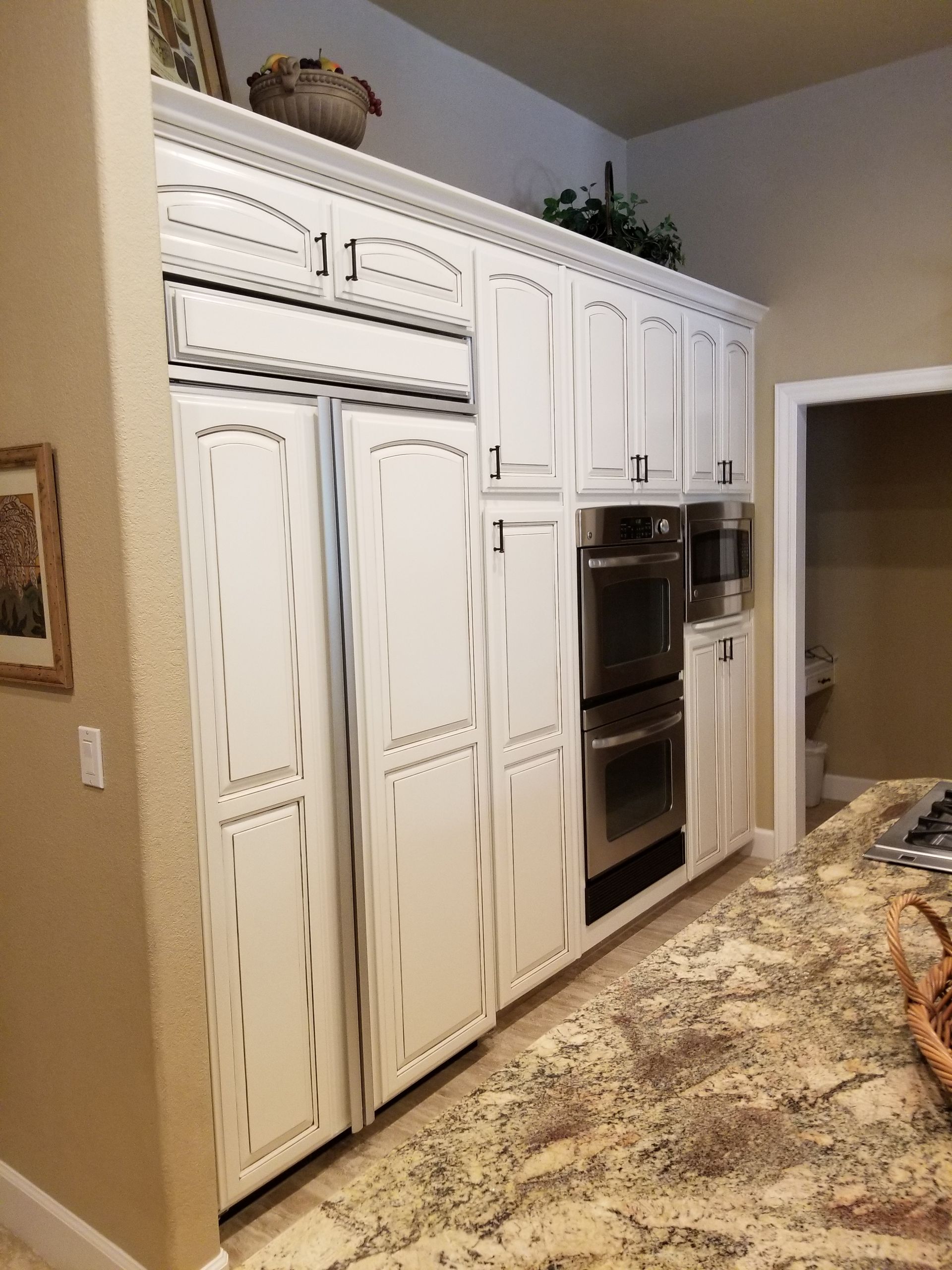 A kitchen with white cabinets and granite counter tops