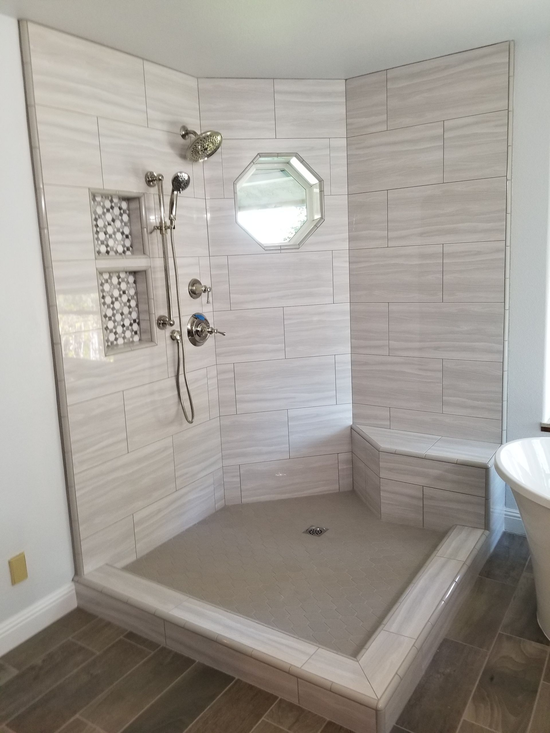 A bathroom with a walk in shower and a sink.