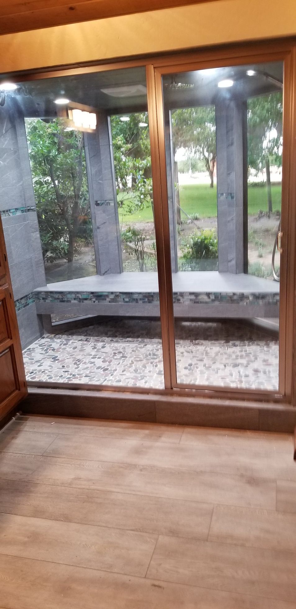 A room with a sliding glass door and a bench in front of it.