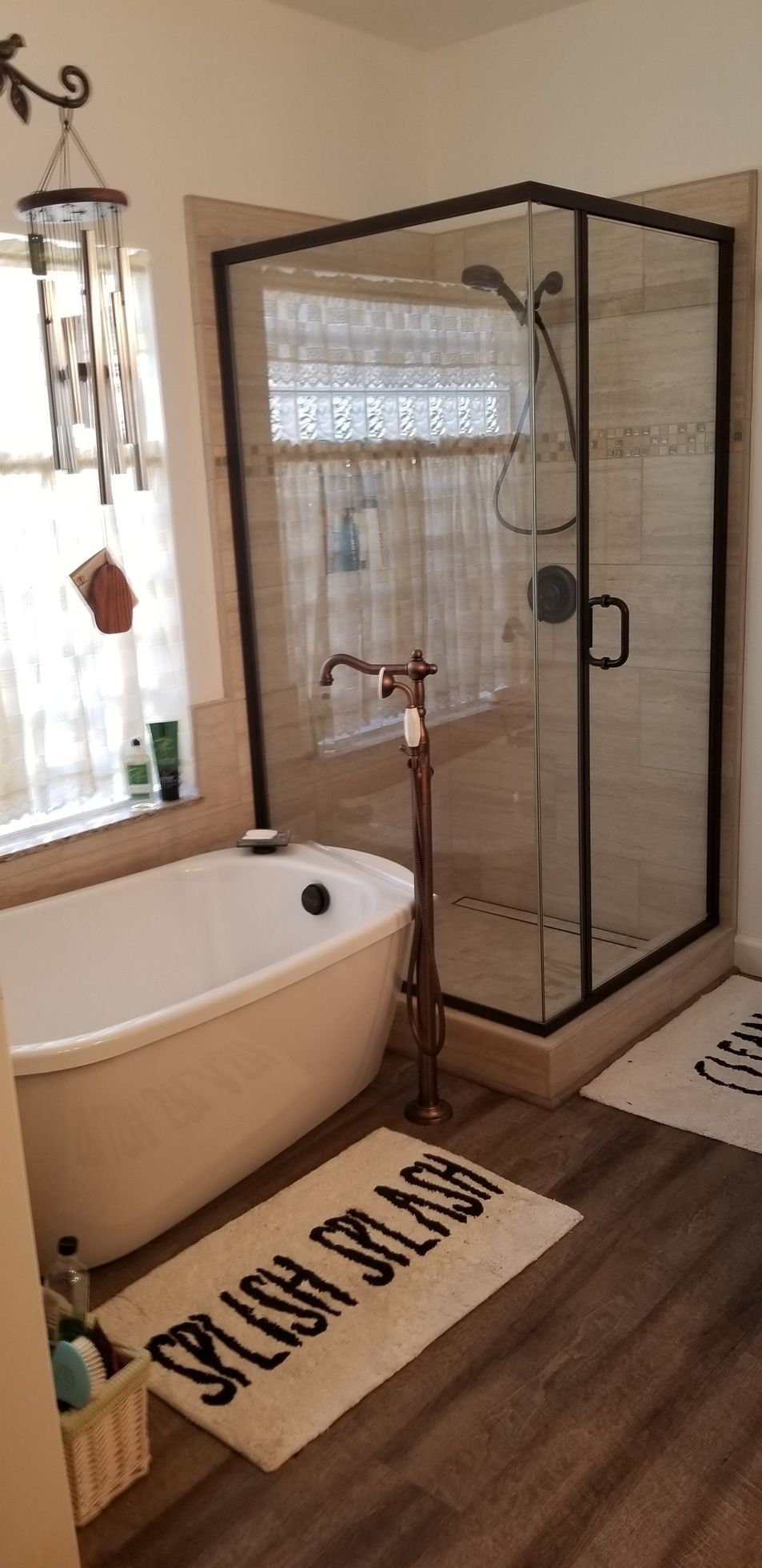 A bathroom with a tub , shower , and window.