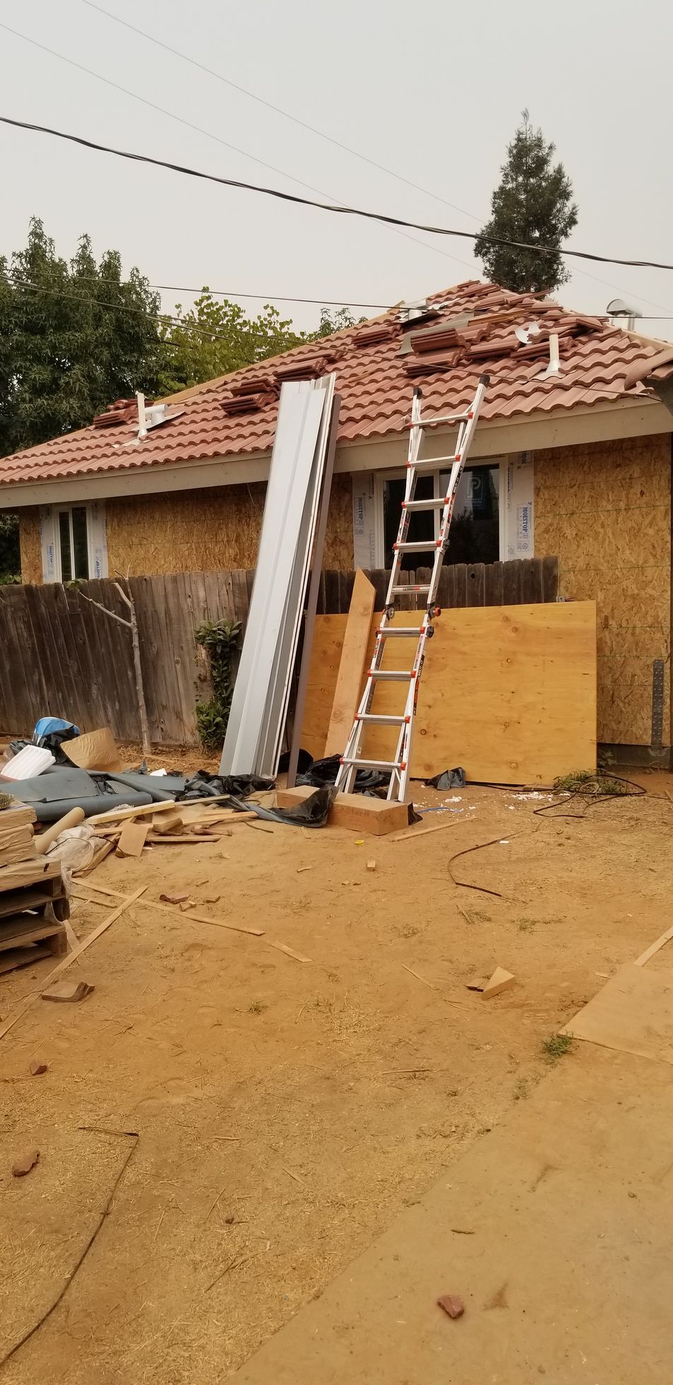 A ladder is sitting in front of a house under construction.
