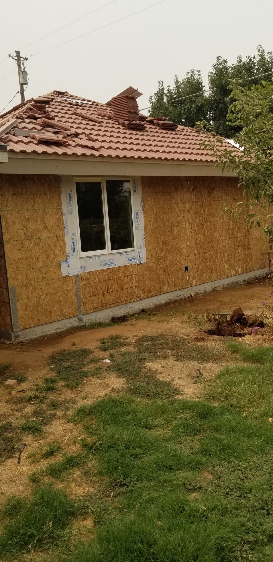 A ladder is sitting in front of a house under construction.