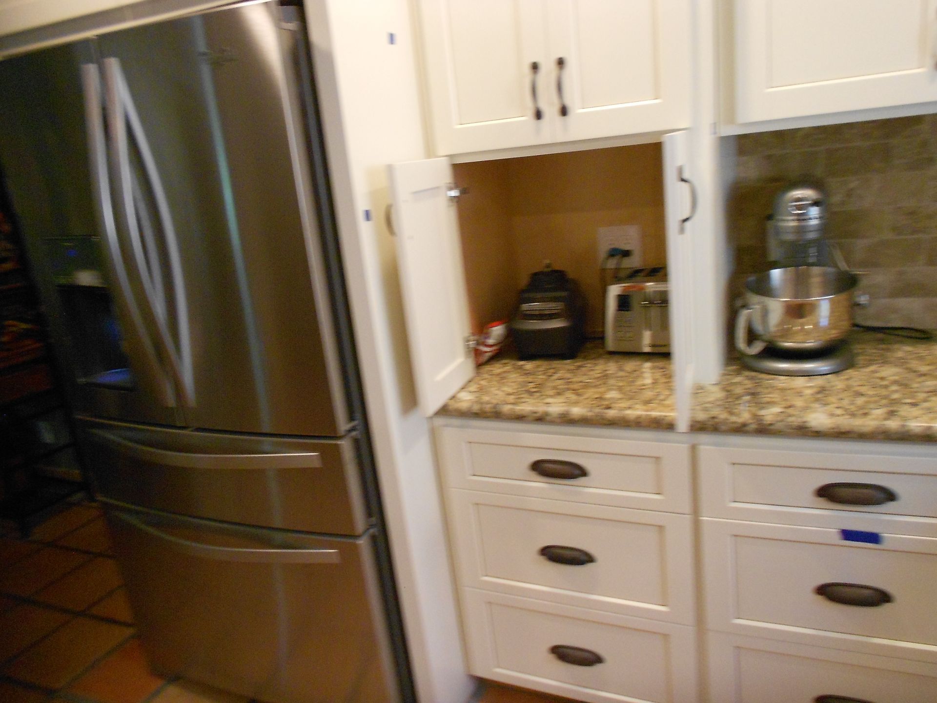 A kitchen with stainless steel appliances and white cabinets
