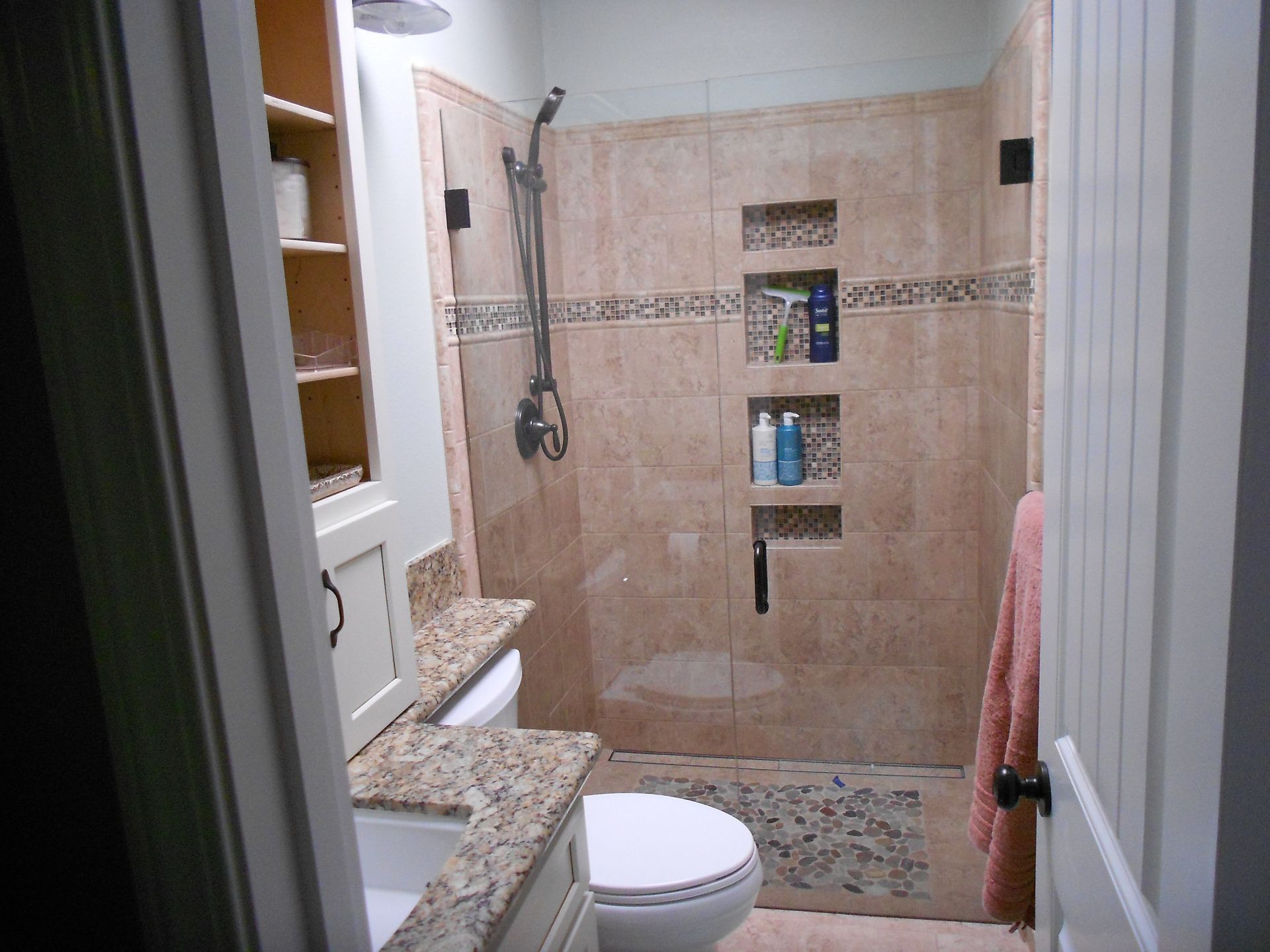A bathroom with a toilet , sink and walk in shower.