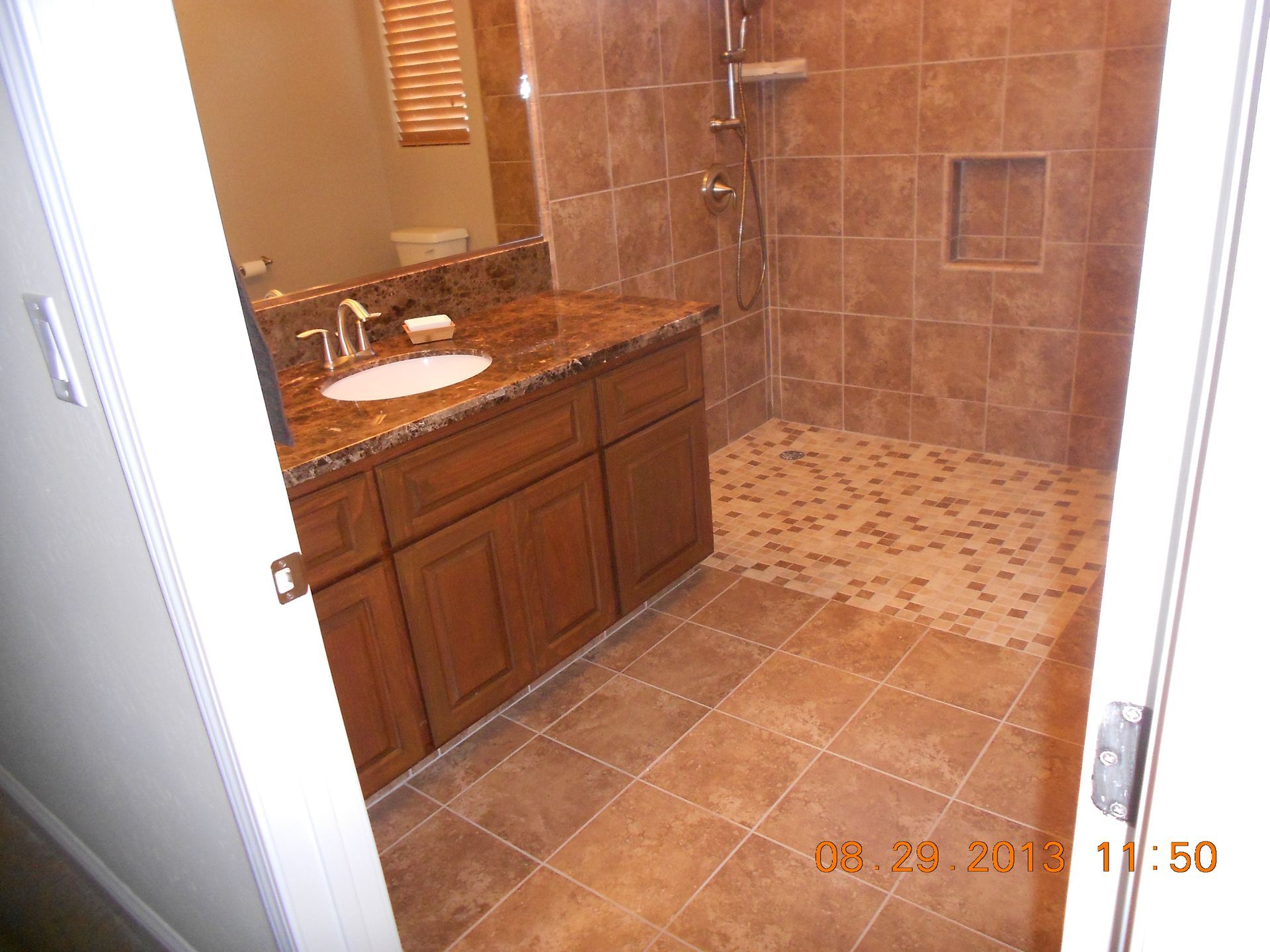 A bathroom with a walk in shower and a sink