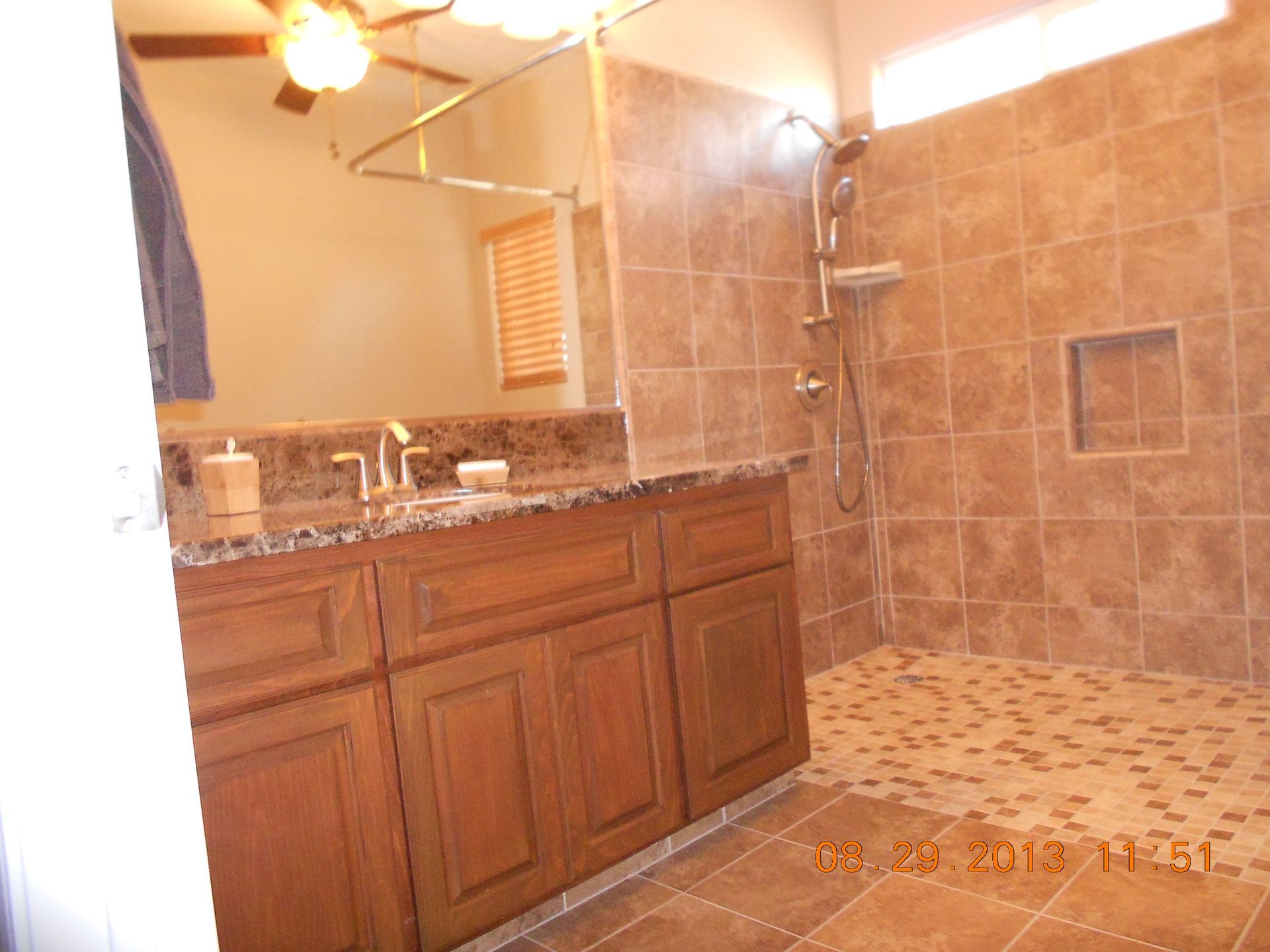A bathroom with a walk in shower and a sink