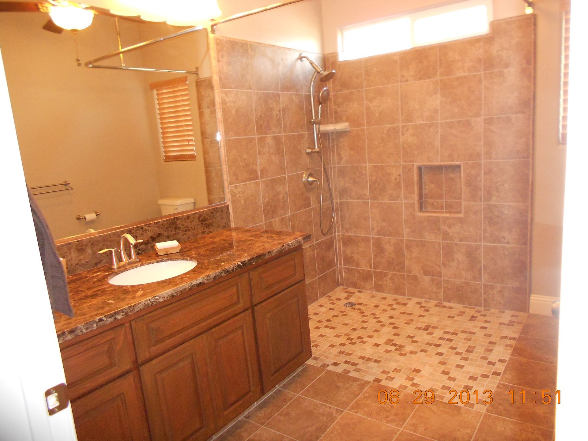 A bathroom with a walk in shower and a sink