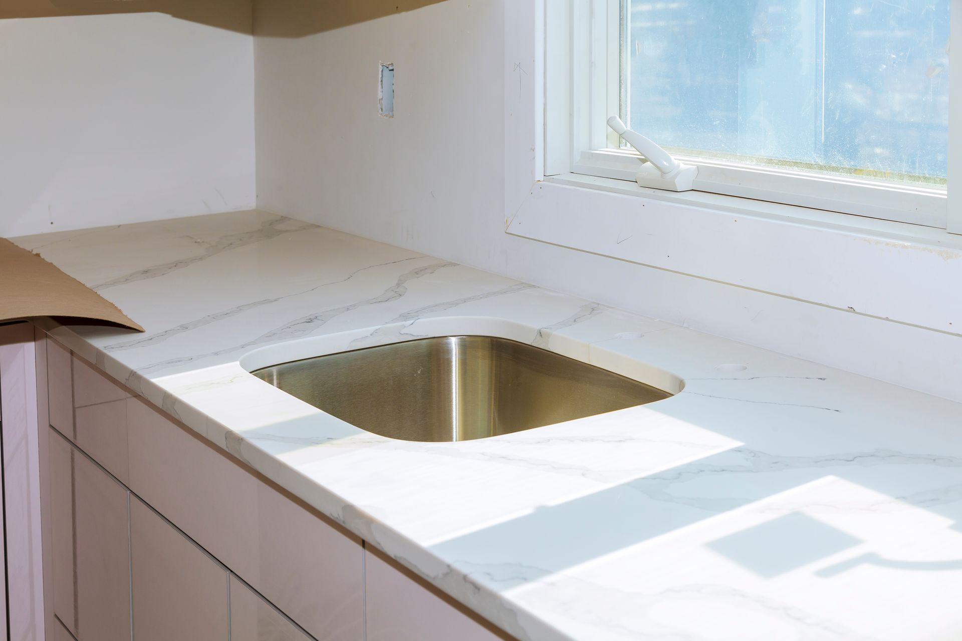 A kitchen counter with a sink and a window.