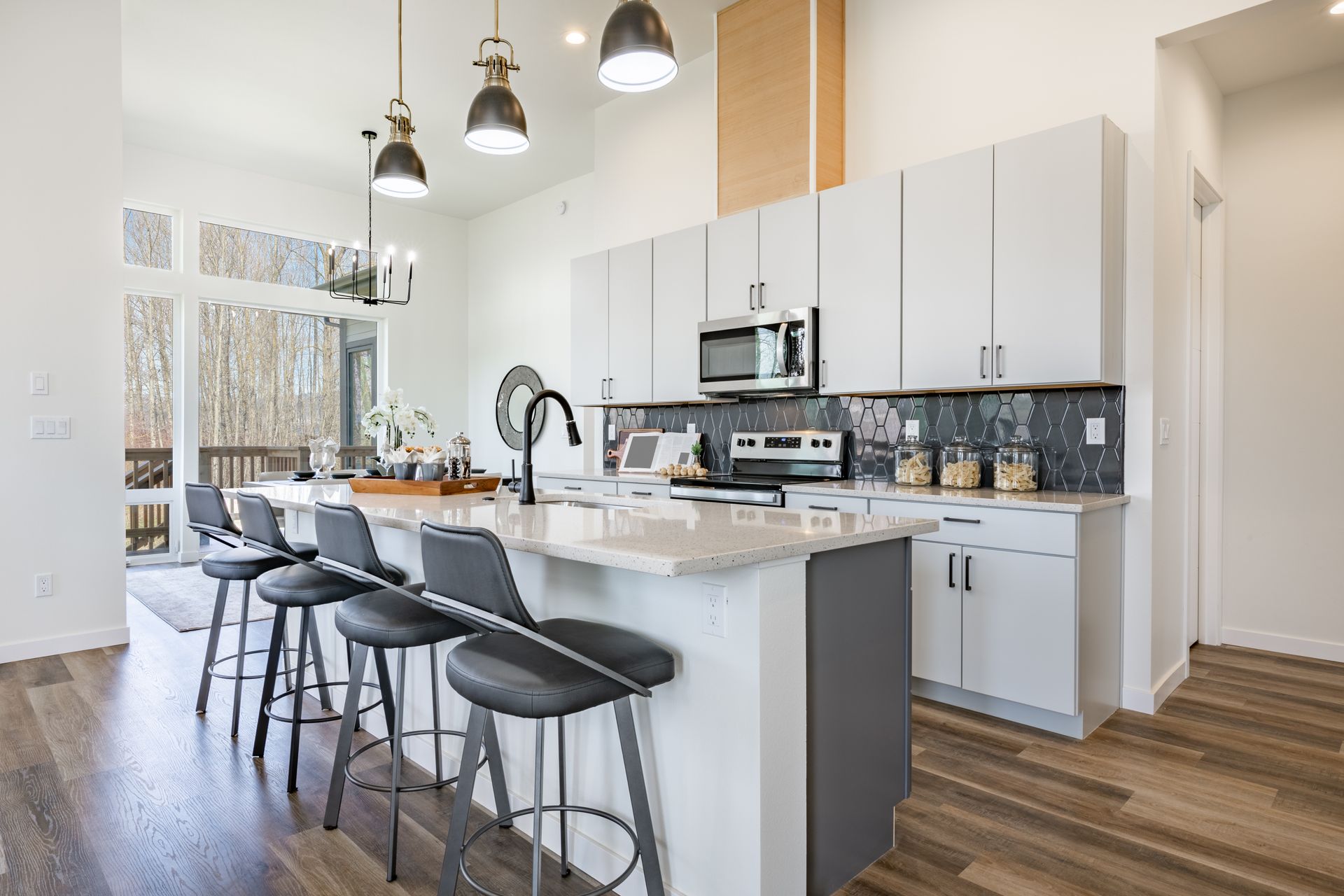 A kitchen with a large island and stools in a house.